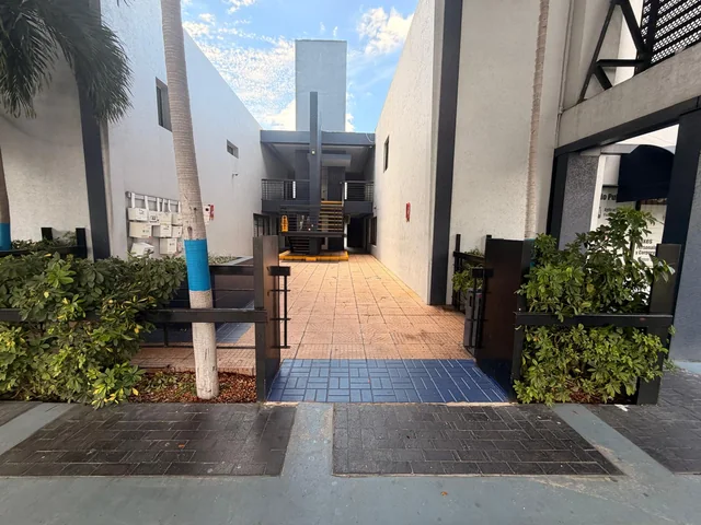Courtyard access with blue tiles, a palm and mailboxes
